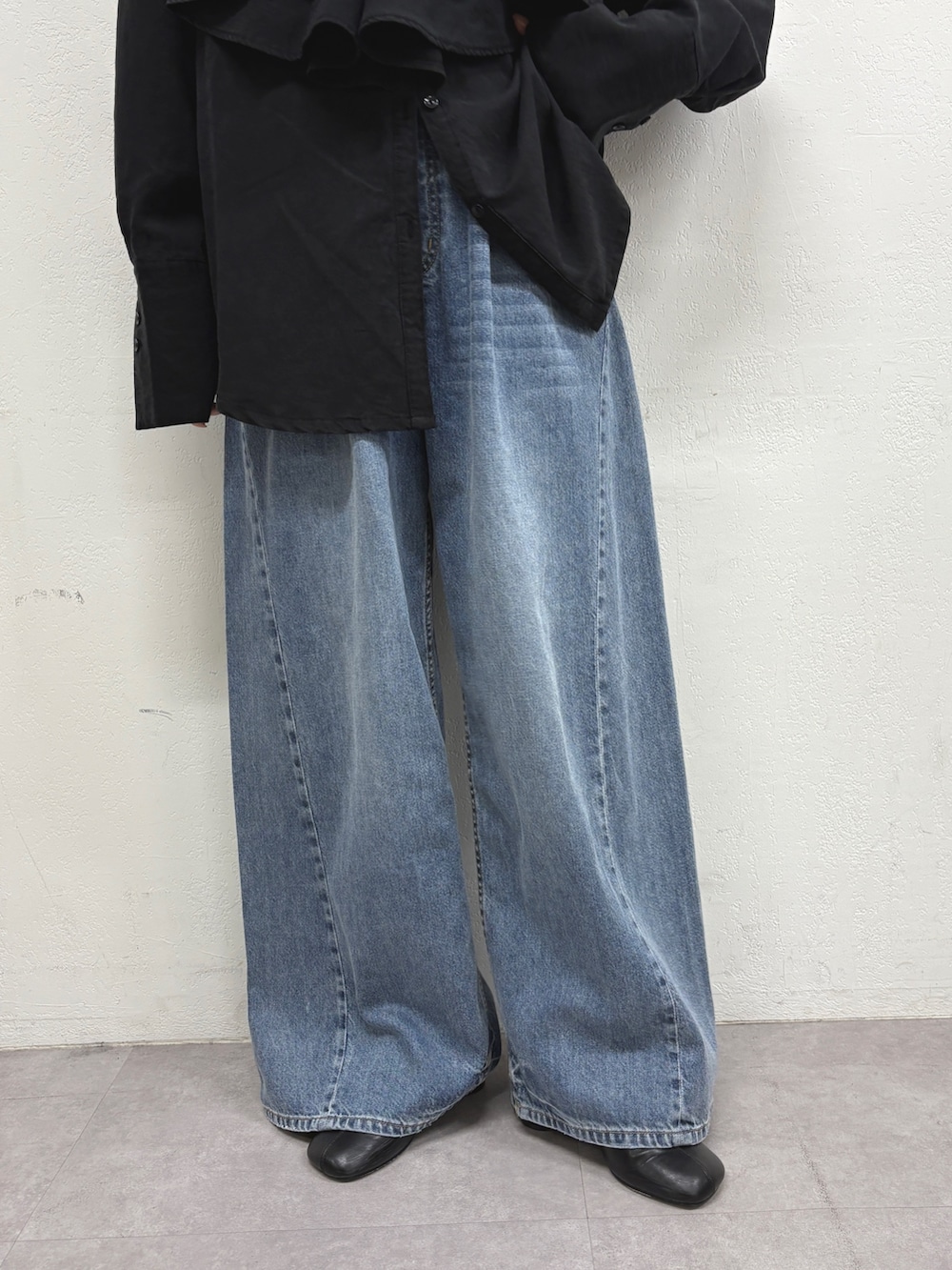 ブラック系のシャツ/ブラウス、ブルー系のデニムパンツ、ブラック系のパンプスを着用したレディースの秋コーディネートの5枚目の写真