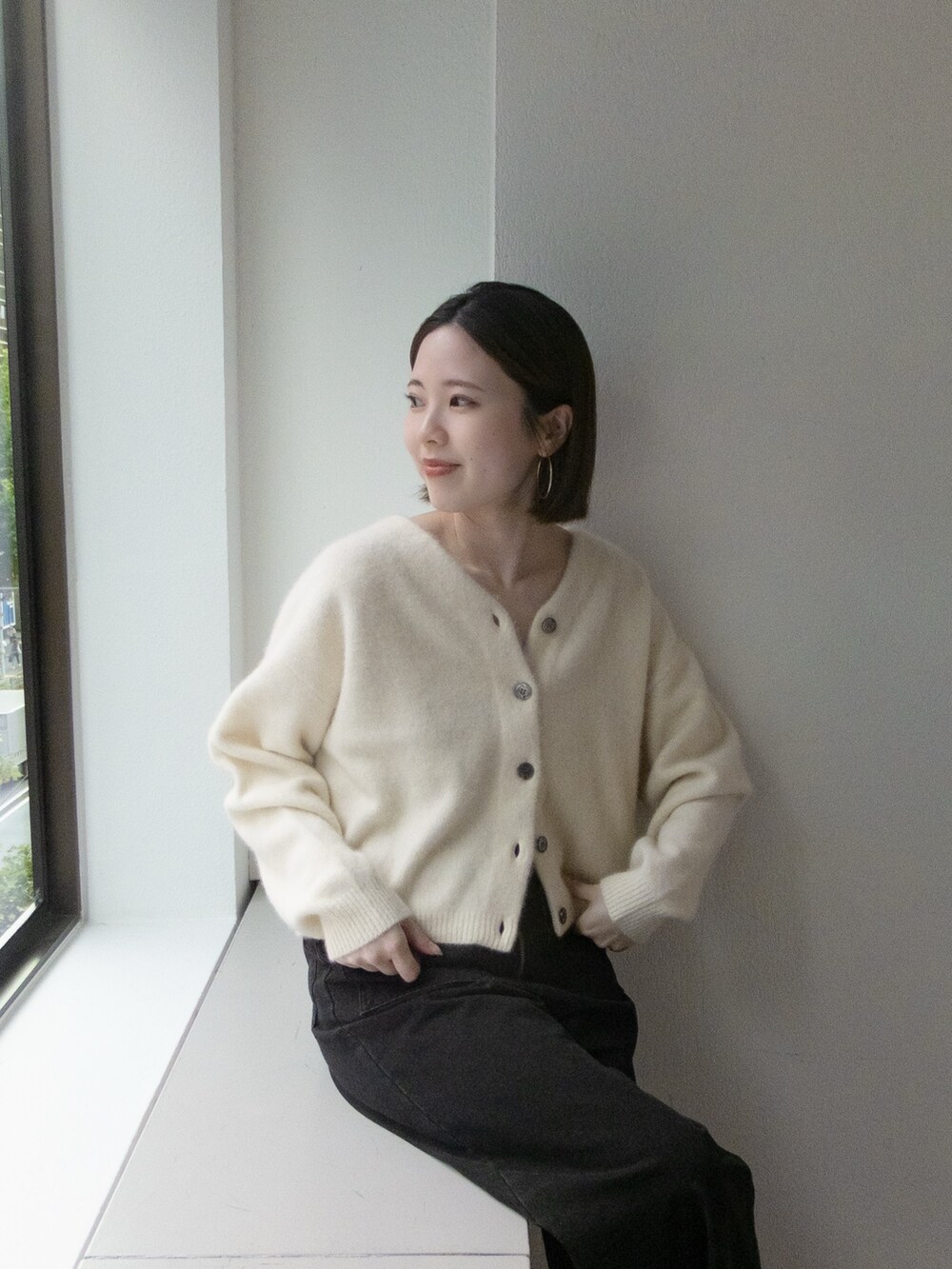 ホワイト系のカーディガン/ボレロ、グレー系のデニムパンツを着用したレディースの秋コーディネートの2枚目の写真