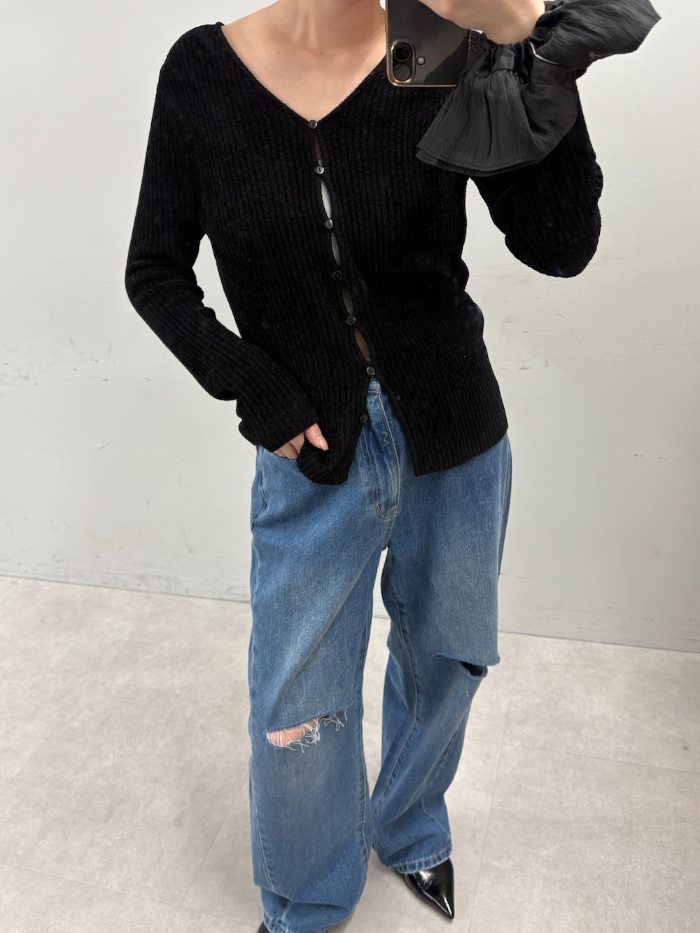 ブラック系のカーディガン/ボレロ、ブルー系のデニムパンツを着用したレディースの秋コーディネートの2枚目の写真