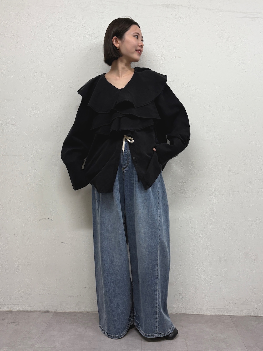 ブラック系のシャツ/ブラウス、ブルー系のデニムパンツ、ブラック系のパンプスを着用したレディースの秋コーディネートの2枚目の写真