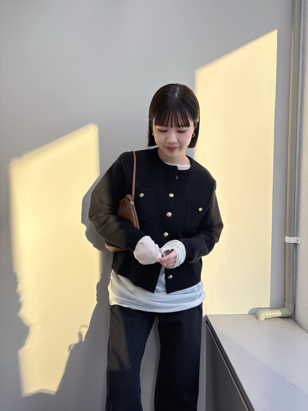 ブラック系のカーディガン/ボレロ、ホワイト系のTシャツ/カットソー、グレー系のデニムパンツを着用したレディースの秋コーディネートの2枚目の写真