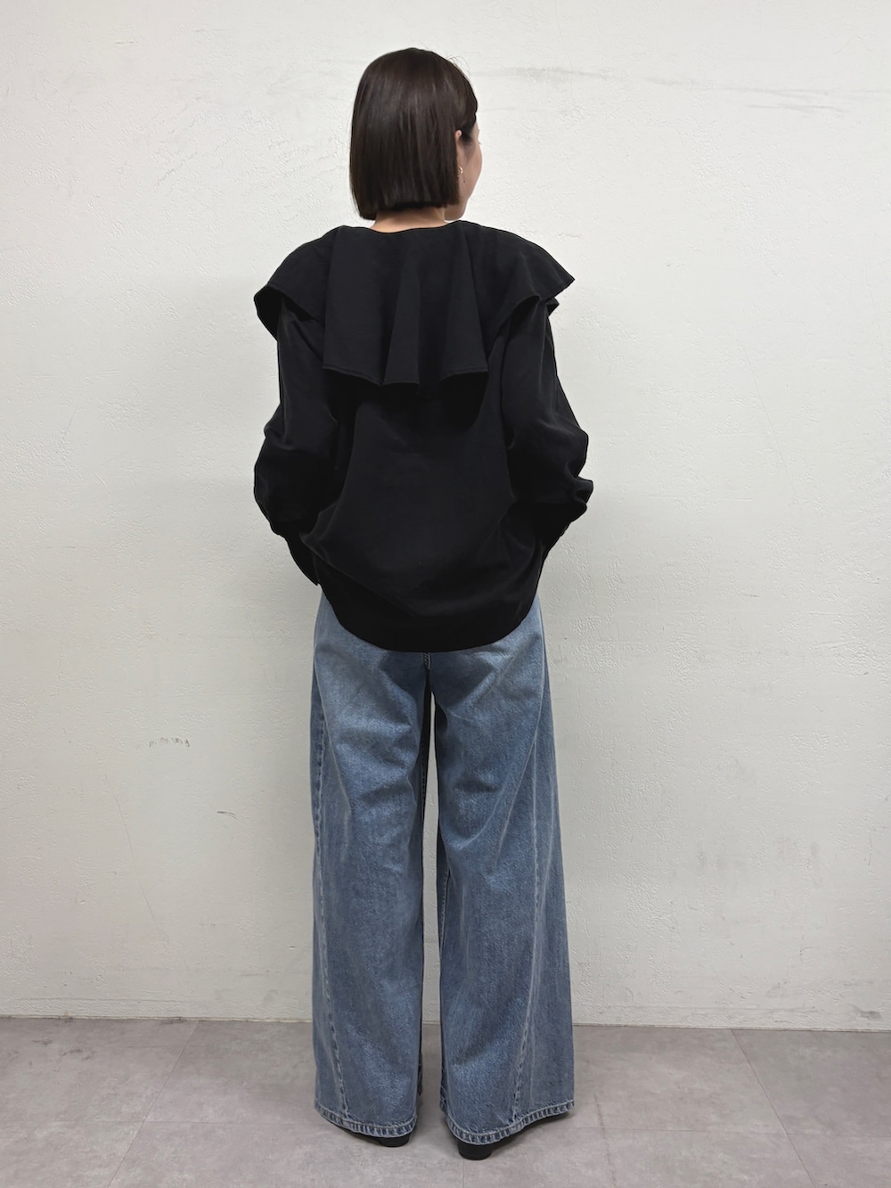 ブラック系のシャツ/ブラウス、ブルー系のデニムパンツ、ブラック系のパンプスを着用したレディースの秋コーディネートの3枚目の写真