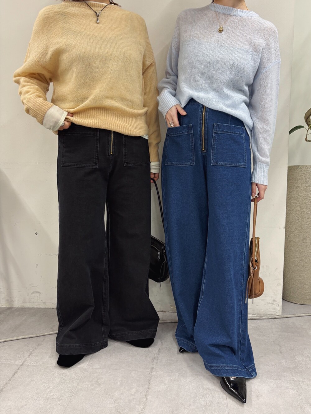 ブルー系のデニムパンツ、ブラック系のパンプス、ホワイト系のニット/セーターを着用したレディースの秋コーディネートの3枚目の写真