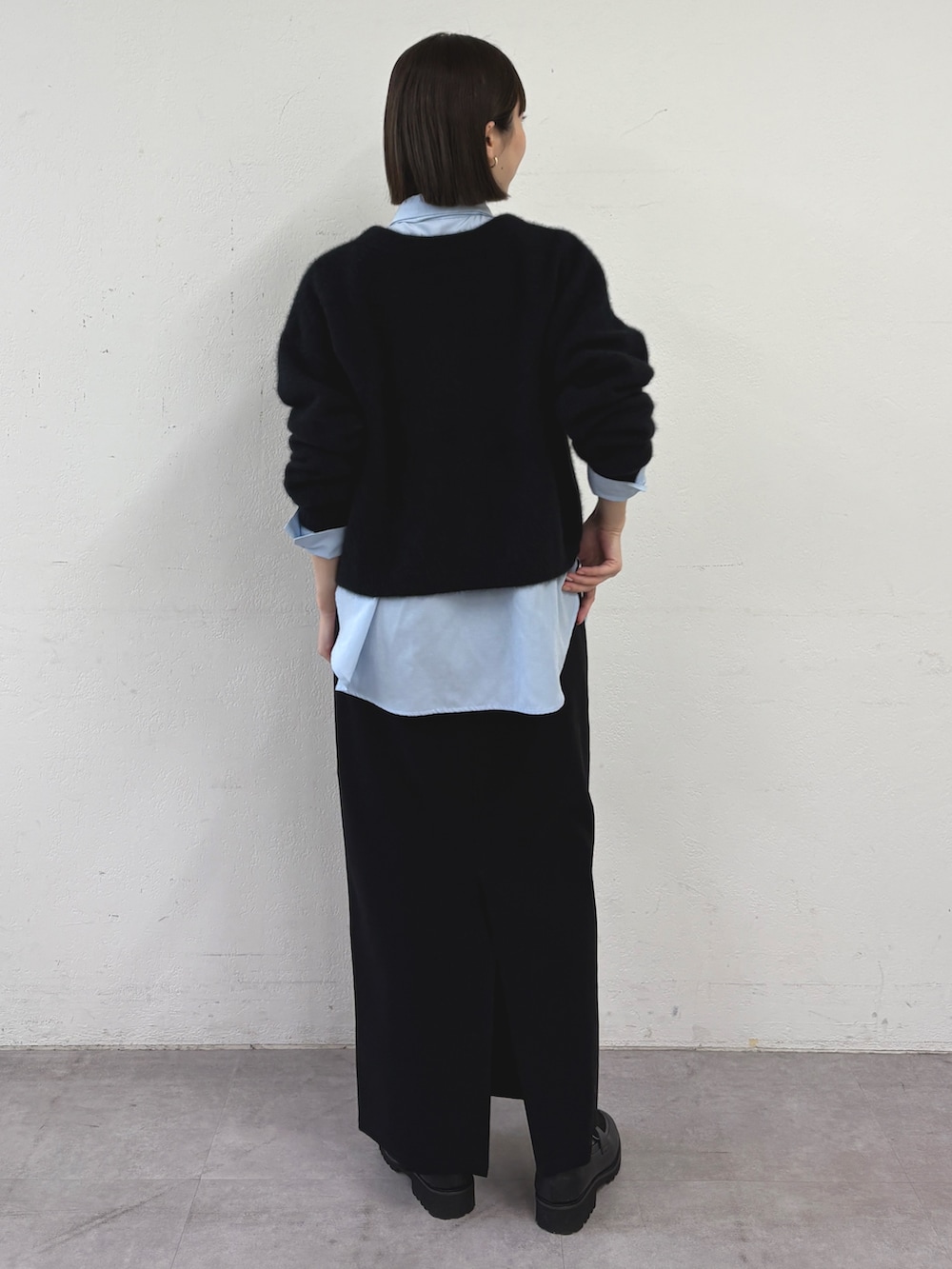 ブラック系のカーディガン/ボレロ、ブルー系のシャツ/ブラウス、ブラック系のスカートを着用したレディースの秋コーディネートの3枚目の写真