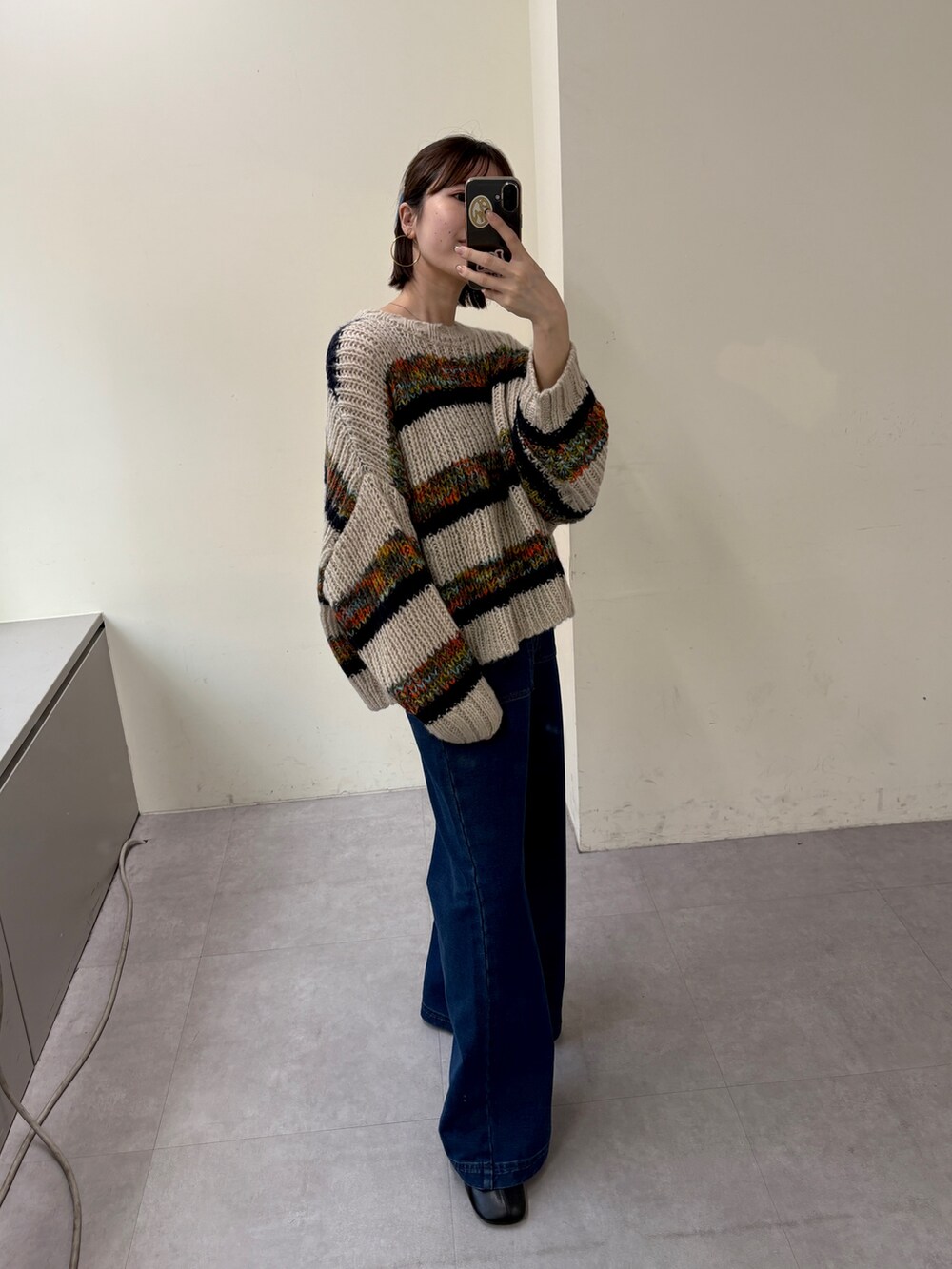 ブルー系のニット/セーター、ブルー系のデニムパンツを着用したレディースの秋コーディネートの5枚目の写真