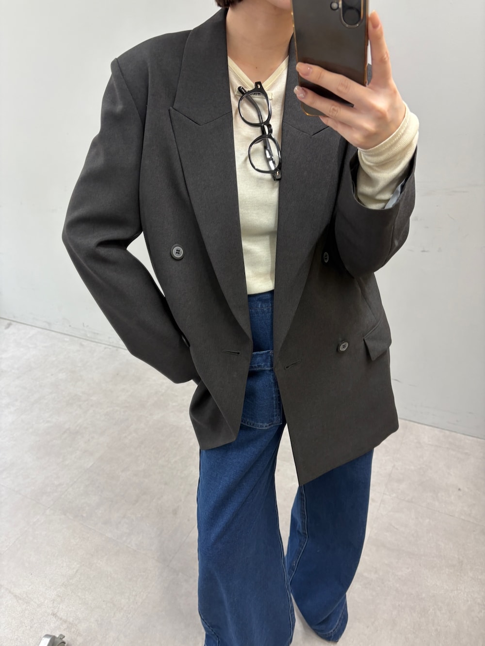 グレー系のテーラードジャケット、イエロー系のTシャツ/カットソー、ブルー系のデニムパンツを着用したレディースの秋コーディネートの2枚目の写真