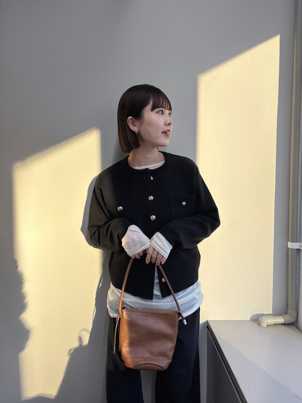 ブラック系のカーディガン/ボレロ、ホワイト系のTシャツ/カットソー、グレー系のデニムパンツを着用したレディースの秋コーディネートの3枚目の写真