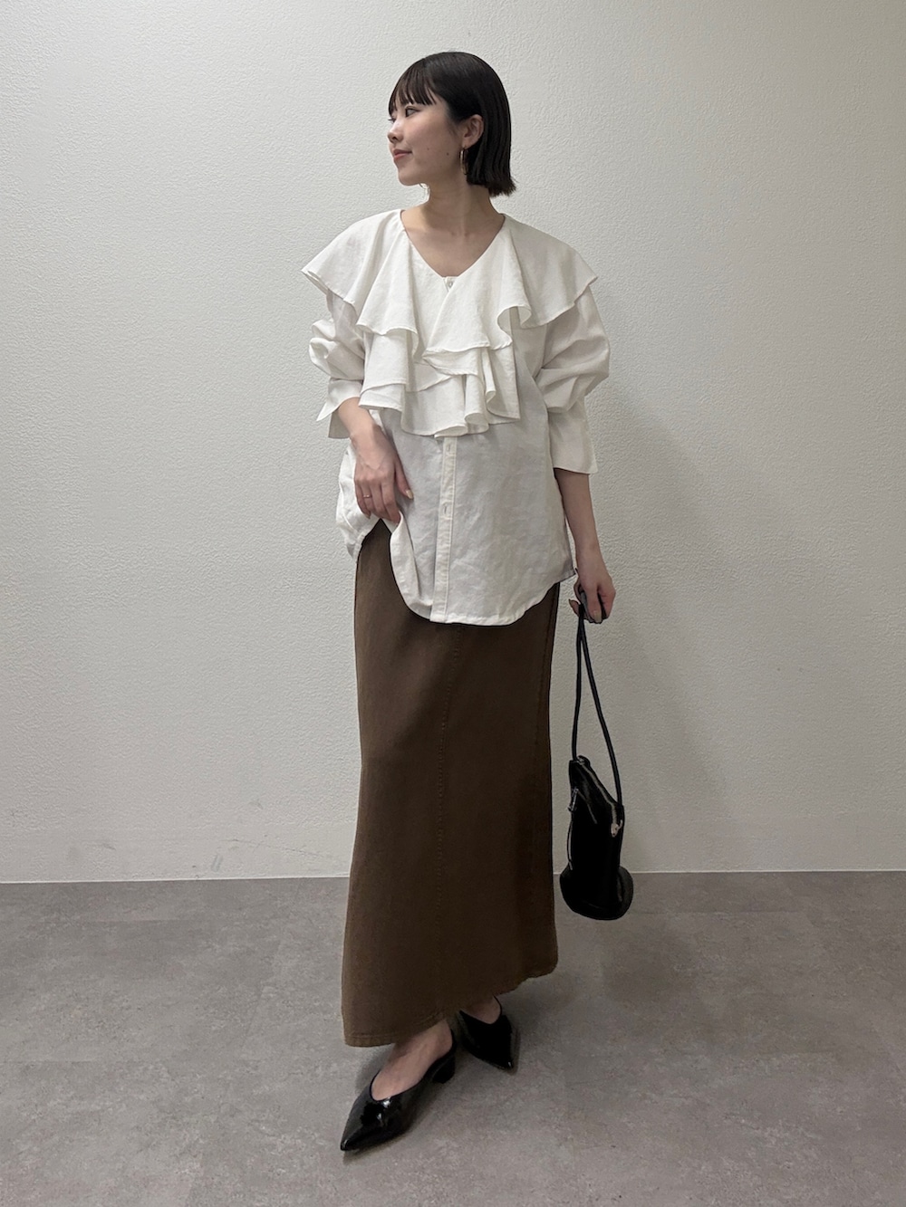 ホワイト系のシャツ/ブラウス、ブラウン系のスカート、ブラウン系のトートバッグを着用したレディースの冬コーディネートの2枚目の写真