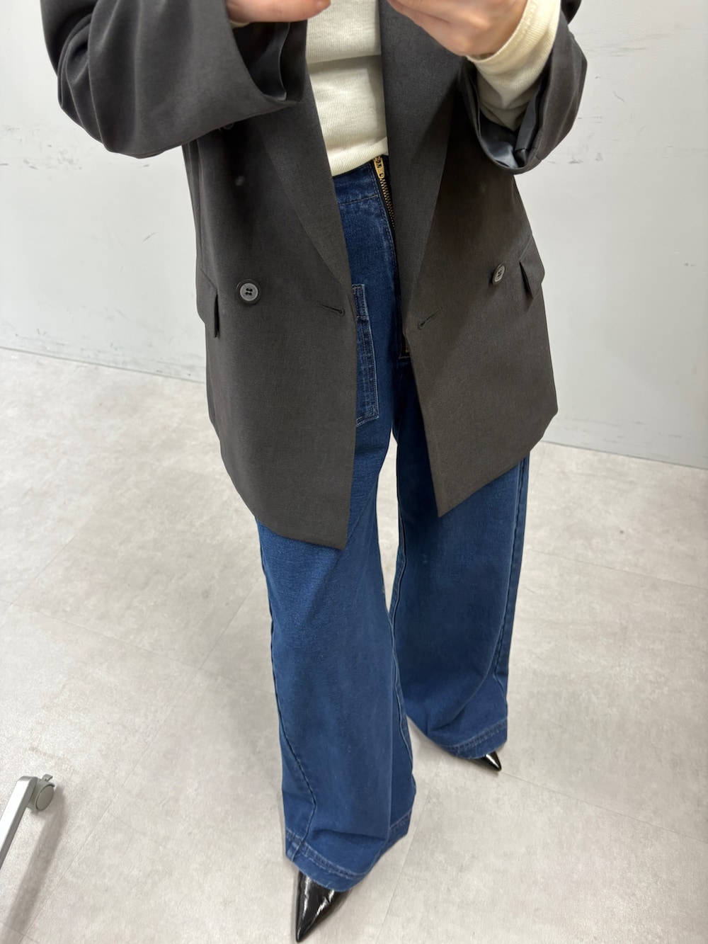 グレー系のテーラードジャケット、イエロー系のTシャツ/カットソー、ブルー系のデニムパンツを着用したレディースの秋コーディネートの3枚目の写真