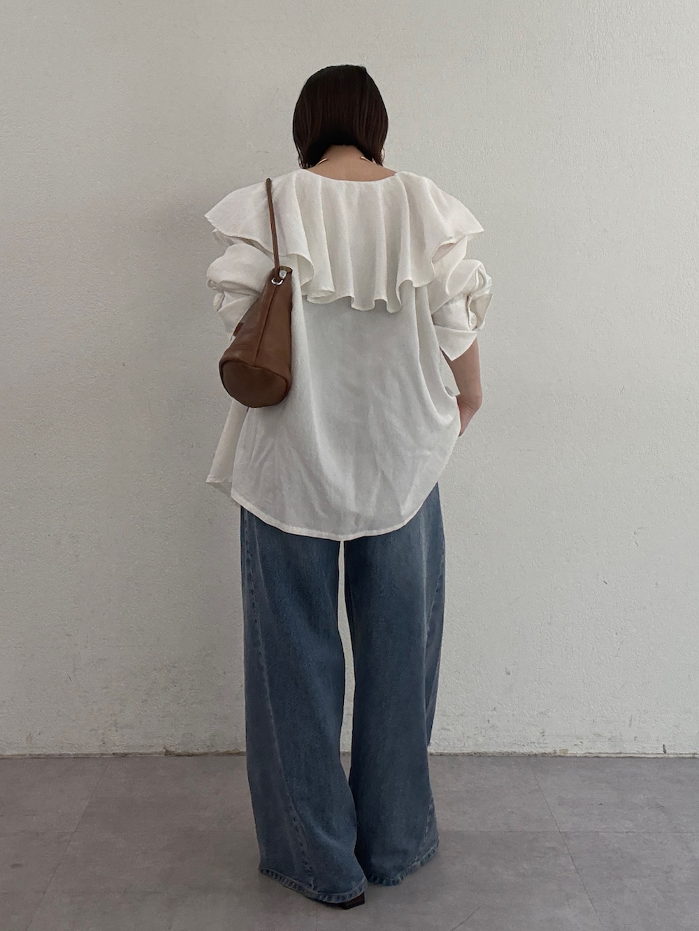 ホワイト系のシャツ/ブラウス、ブラウン系のトートバッグ、ブルー系のデニムパンツを着用したレディースの冬コーディネートの3枚目の写真