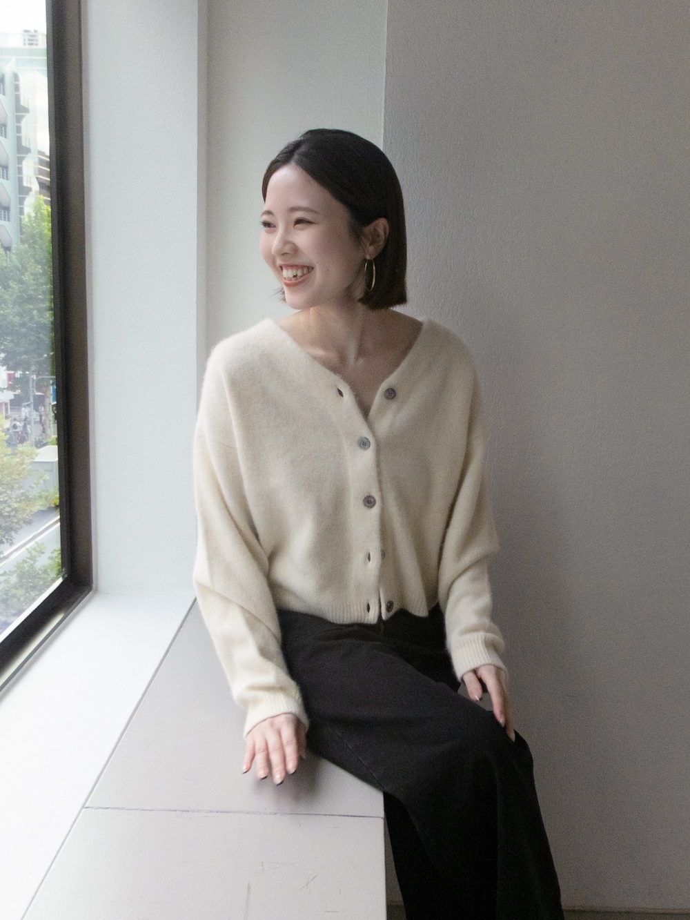 ホワイト系のカーディガン/ボレロ、グレー系のデニムパンツを着用したレディースの秋コーディネートの3枚目の写真