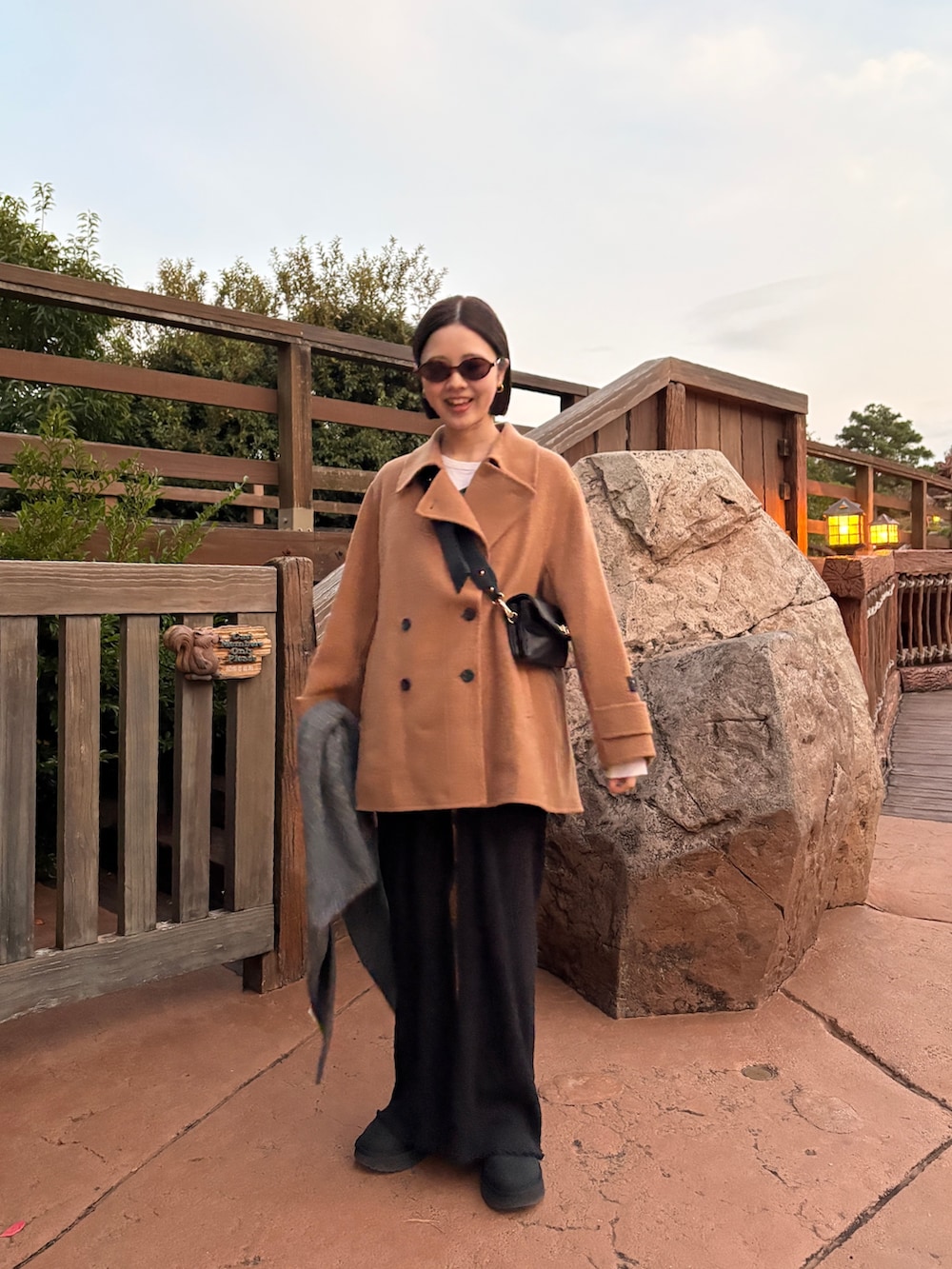 イエロー系のピーコート、ブラック系のその他パンツ、ブラック系のその他シューズを着用したレディースの秋コーディネートの2枚目の写真