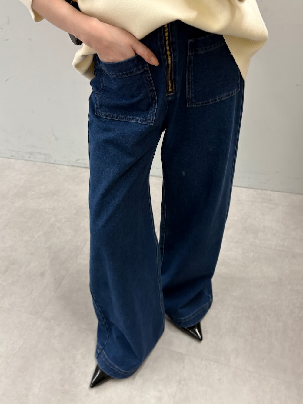 ホワイト系のニット/セーター、ブルー系のデニムパンツを着用したレディースの秋コーディネートの3枚目の写真