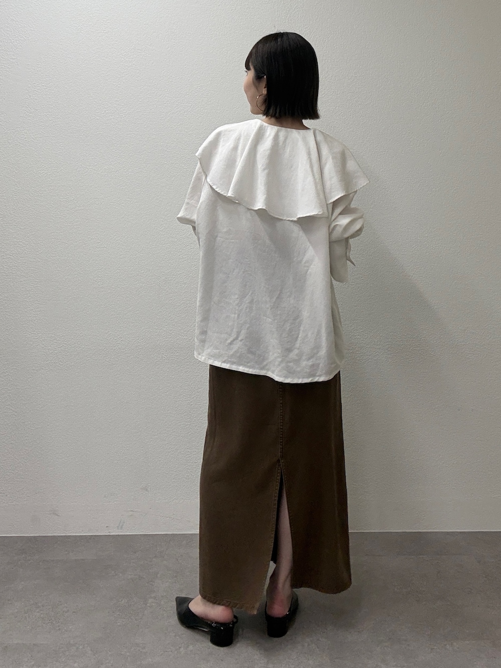 ホワイト系のシャツ/ブラウス、ブラウン系のスカート、ブラウン系のトートバッグを着用したレディースの冬コーディネートの3枚目の写真