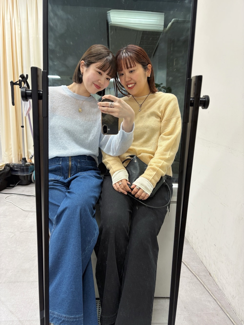 ブルー系のデニムパンツ、ブラック系のパンプス、ホワイト系のニット/セーターを着用したレディースの秋コーディネートの4枚目の写真