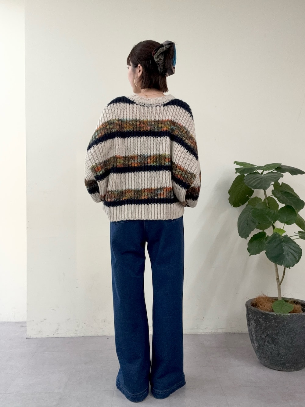 ブルー系のニット/セーター、ブルー系のデニムパンツを着用したレディースの秋コーディネートの3枚目の写真