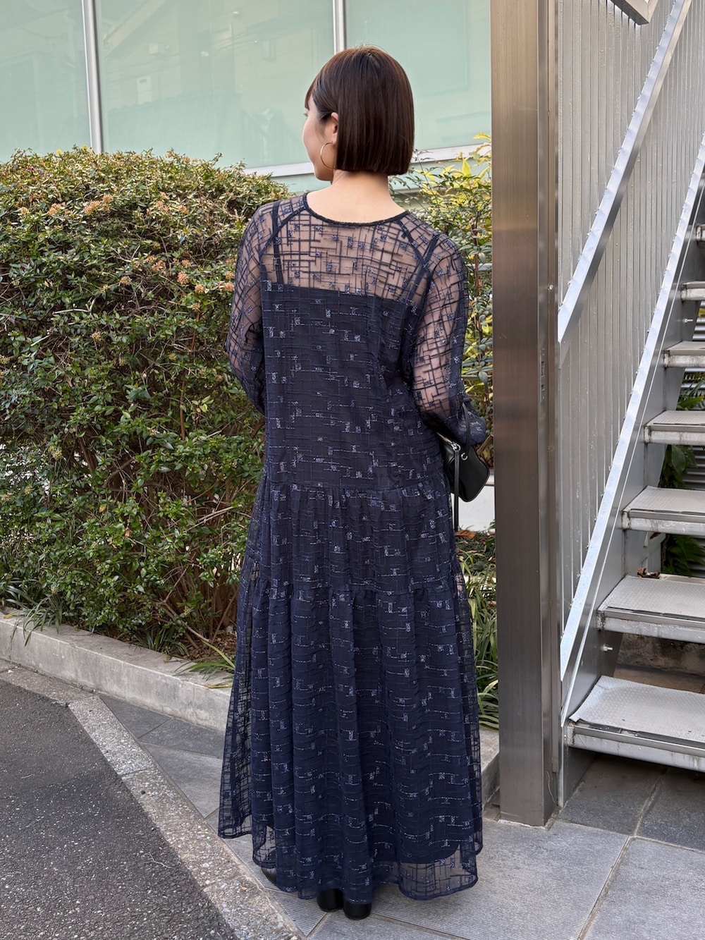 ブラック系のムートンコート、ブルー系のワンピース、ブラック系のブーツを着用したレディースの冬コーディネートの5枚目の写真