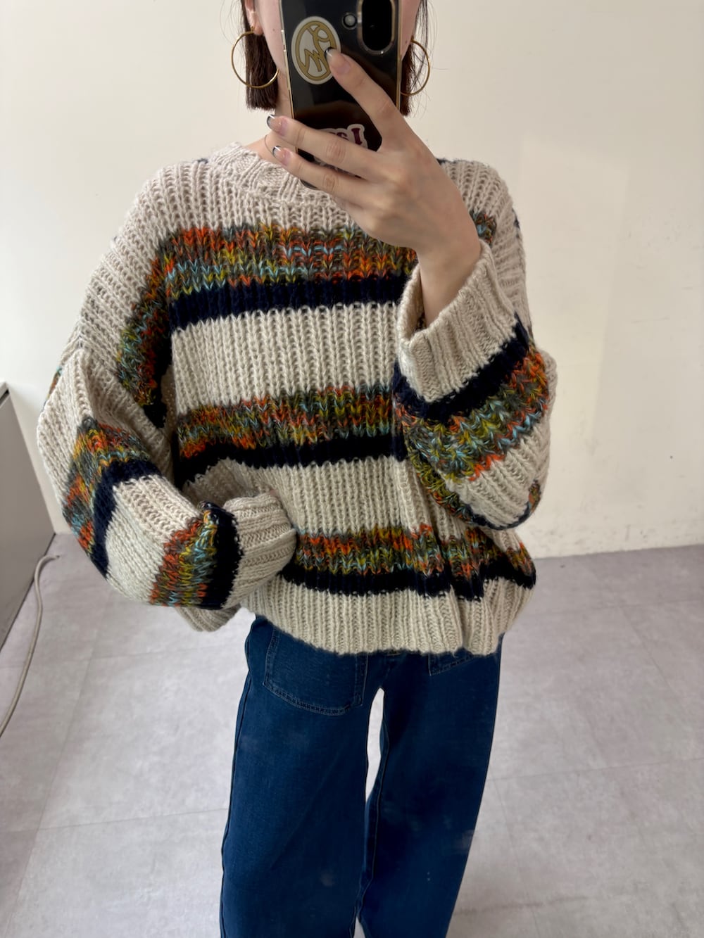 ブルー系のニット/セーター、ブルー系のデニムパンツを着用したレディースの秋コーディネートの4枚目の写真