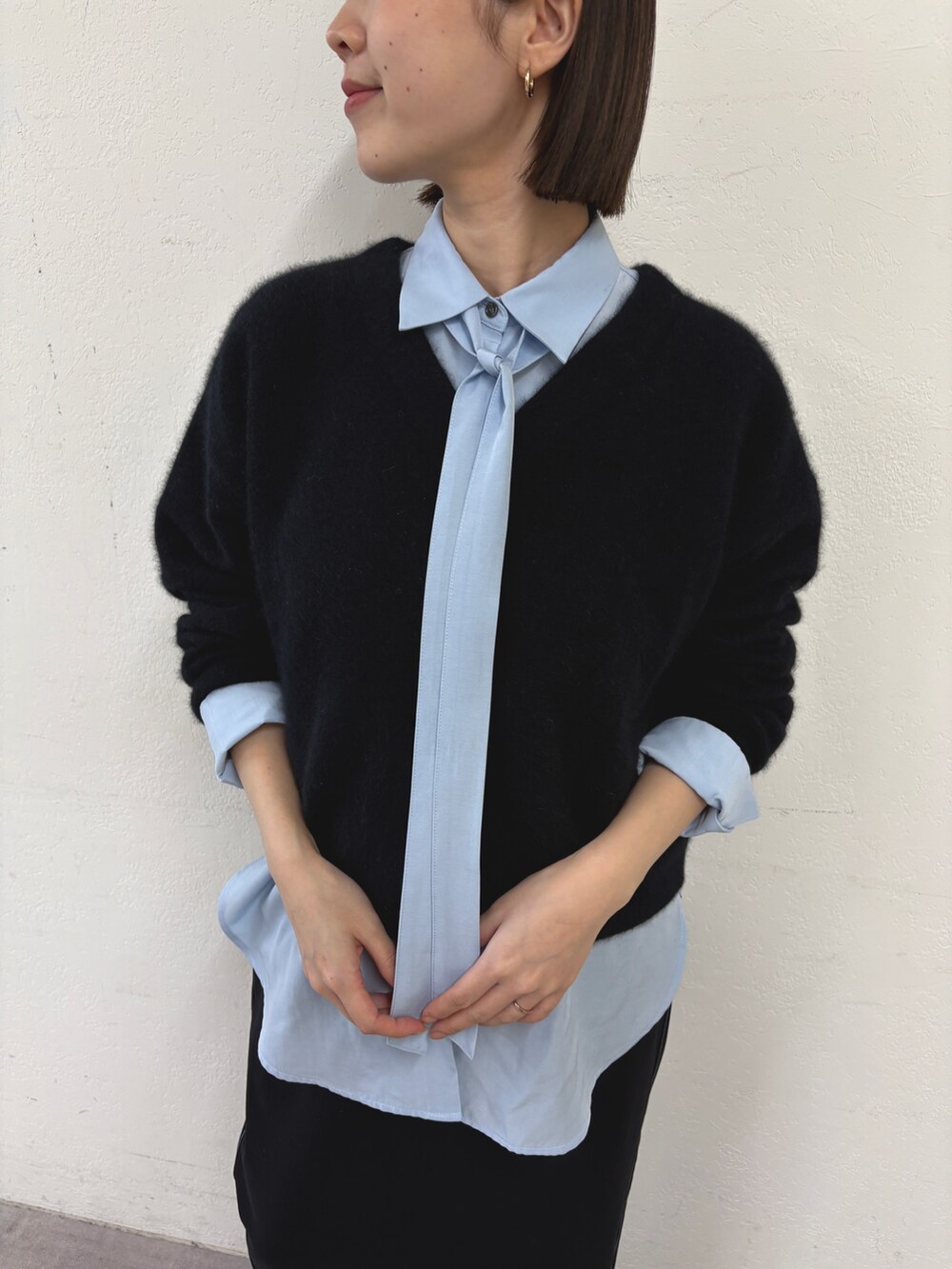 ブラック系のカーディガン/ボレロ、ブルー系のシャツ/ブラウス、ブラック系のスカートを着用したレディースの秋コーディネートの4枚目の写真