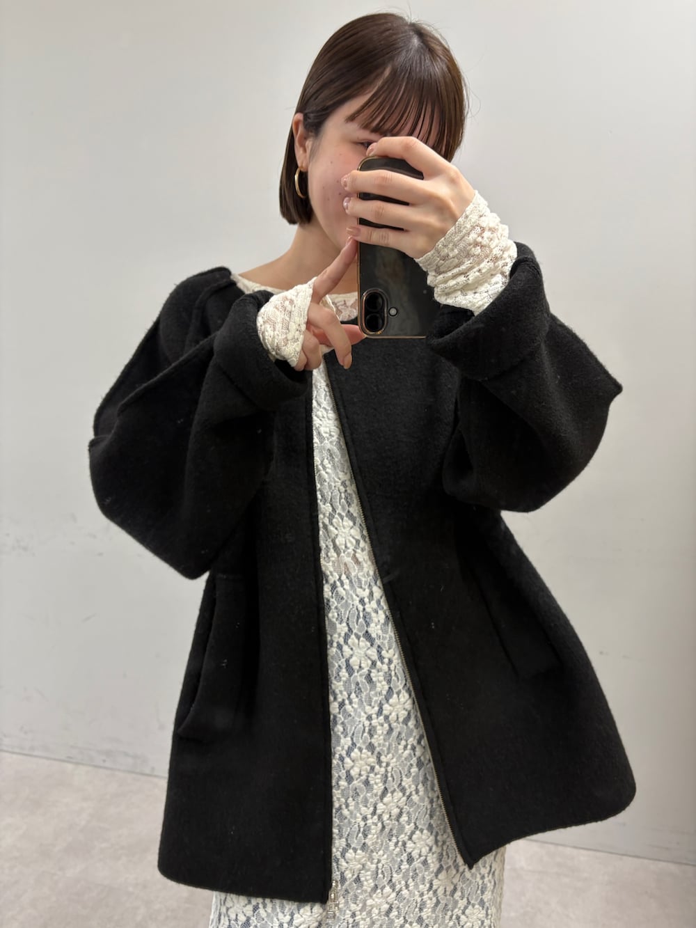 ブラック系のその他アウター、ホワイト系のワンピース、ブルー系のデニムパンツを着用したレディースの秋コーディネートの2枚目の写真