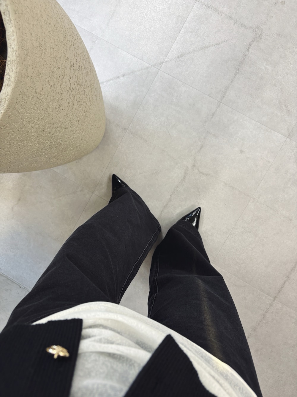 ブラック系のカーディガン/ボレロ、ホワイト系のTシャツ/カットソー、グレー系のデニムパンツを着用したレディースの秋コーディネートの4枚目の写真