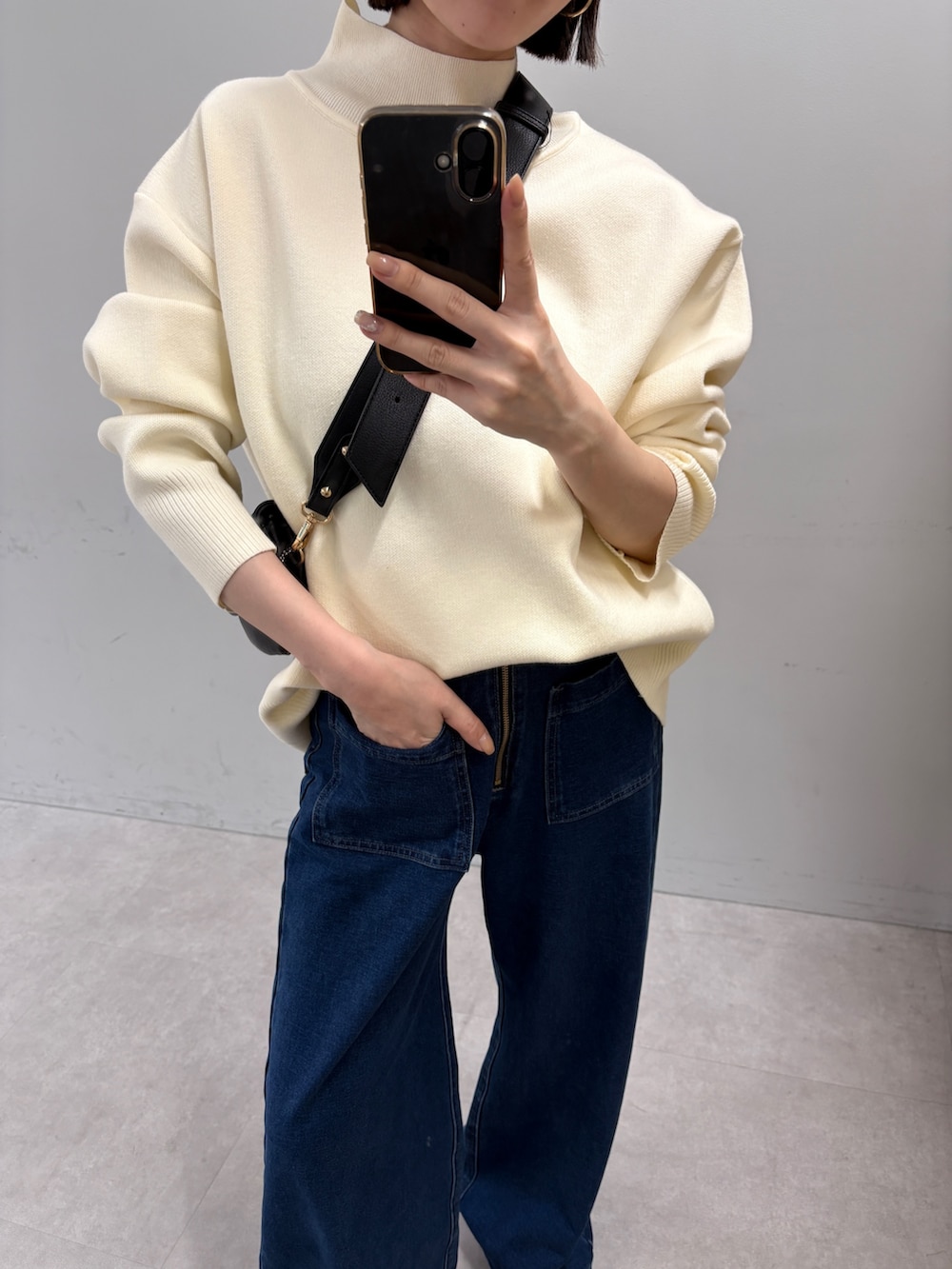 ホワイト系のニット/セーター、ブルー系のデニムパンツを着用したレディースの秋コーディネートの2枚目の写真