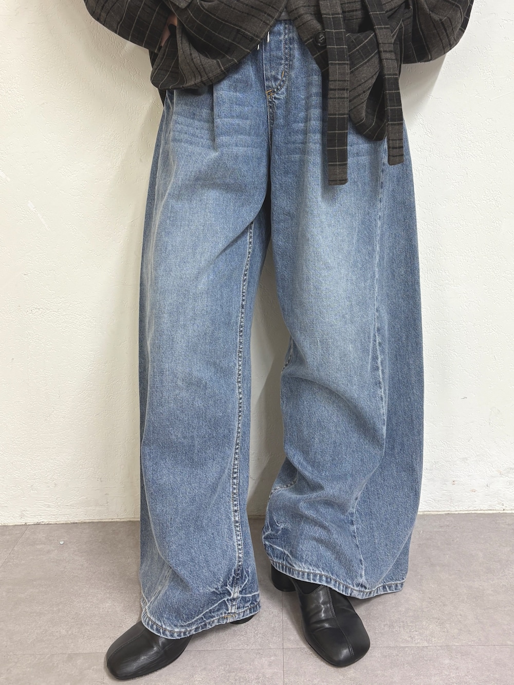 グレー系のテーラードジャケット、グレー系のTシャツ/カットソー、ブルー系のデニムパンツを着用したレディースの秋コーディネートの5枚目の写真