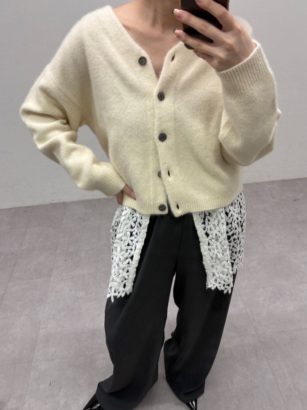 ホワイト系のカーディガン/ボレロ、ブラック系のキャミソール、グレー系のその他パンツを着用したレディースの秋コーディネートの2枚目の写真