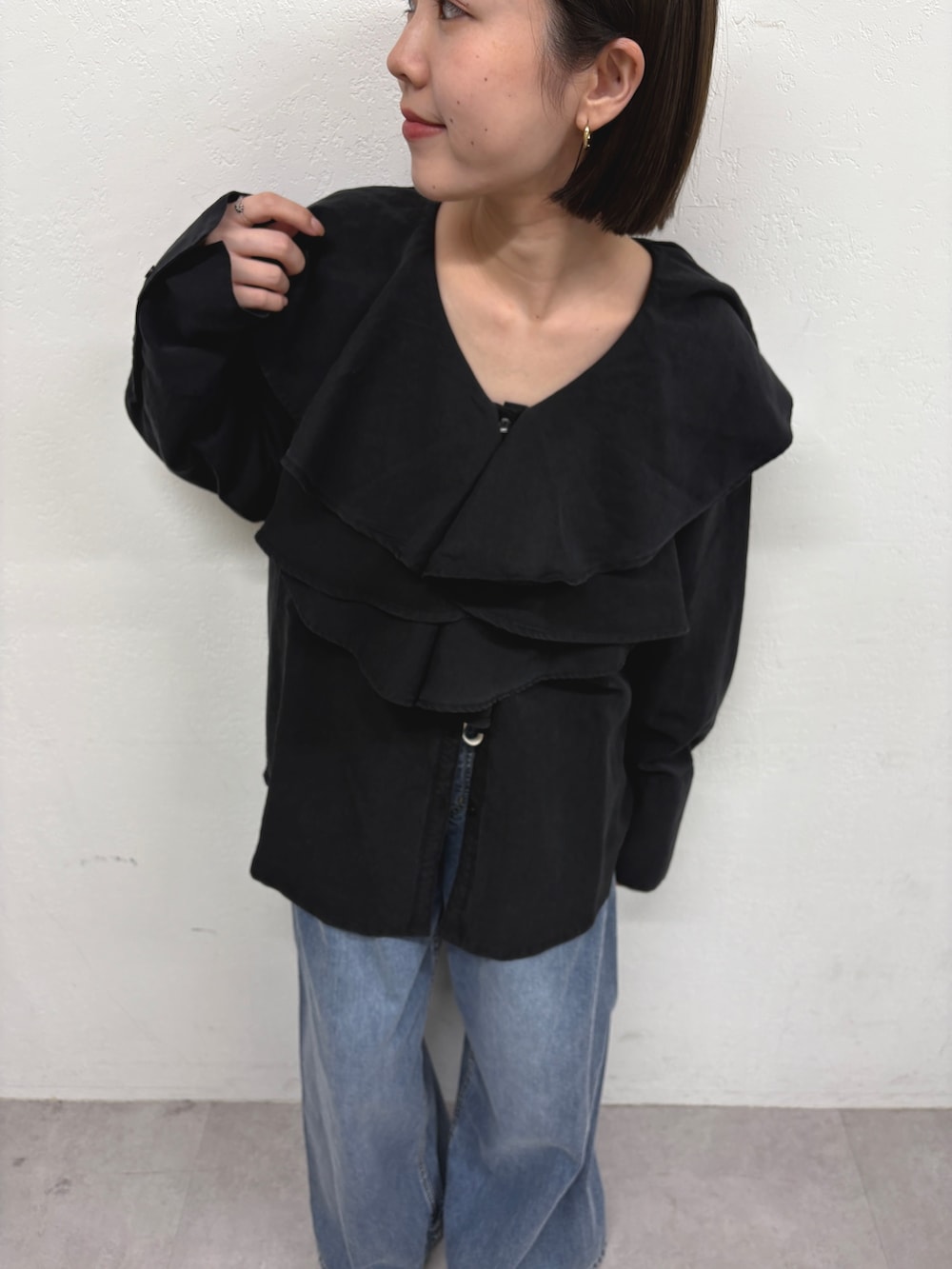 ブラック系のシャツ/ブラウス、ブルー系のデニムパンツ、ブラック系のパンプスを着用したレディースの秋コーディネートの4枚目の写真