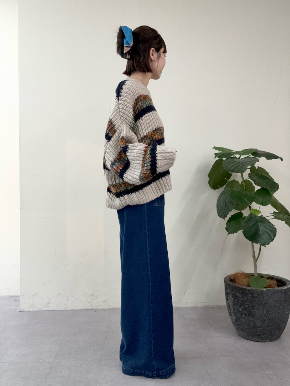 ブルー系のニット/セーター、ブルー系のデニムパンツを着用したレディースの秋コーディネートの2枚目の写真