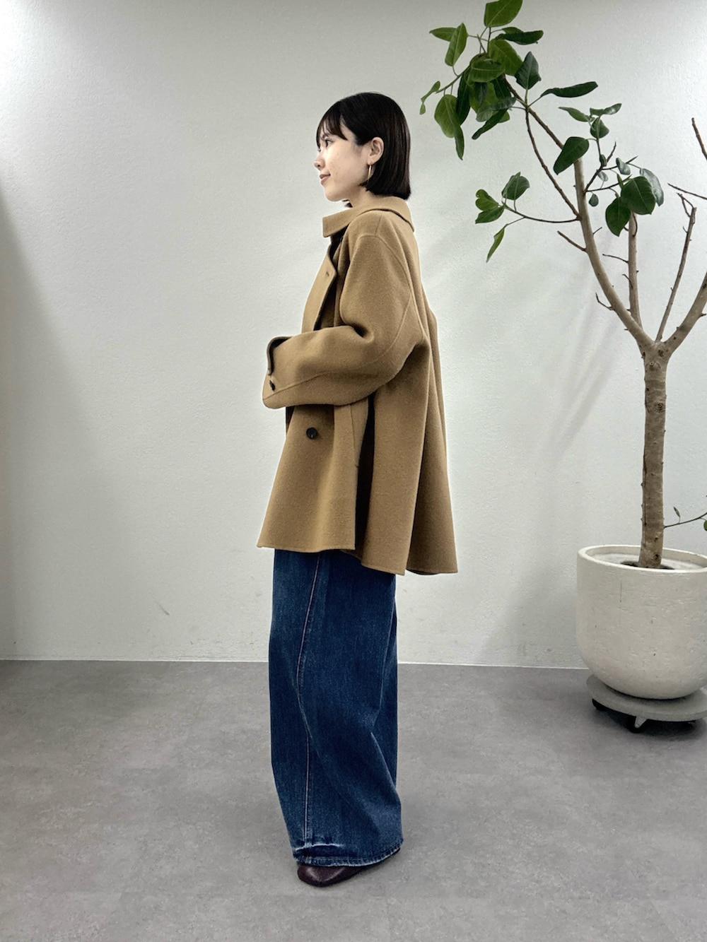 イエロー系のピーコート、ホワイト系のTシャツ/カットソー、レッド系のパンプスを着用したレディースの秋コーディネートの2枚目の写真