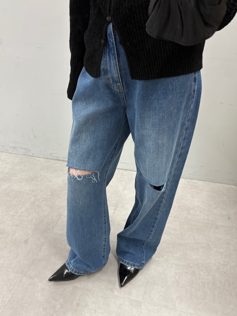 ブラック系のカーディガン/ボレロ、ブルー系のデニムパンツを着用したレディースの秋コーディネートの3枚目の写真