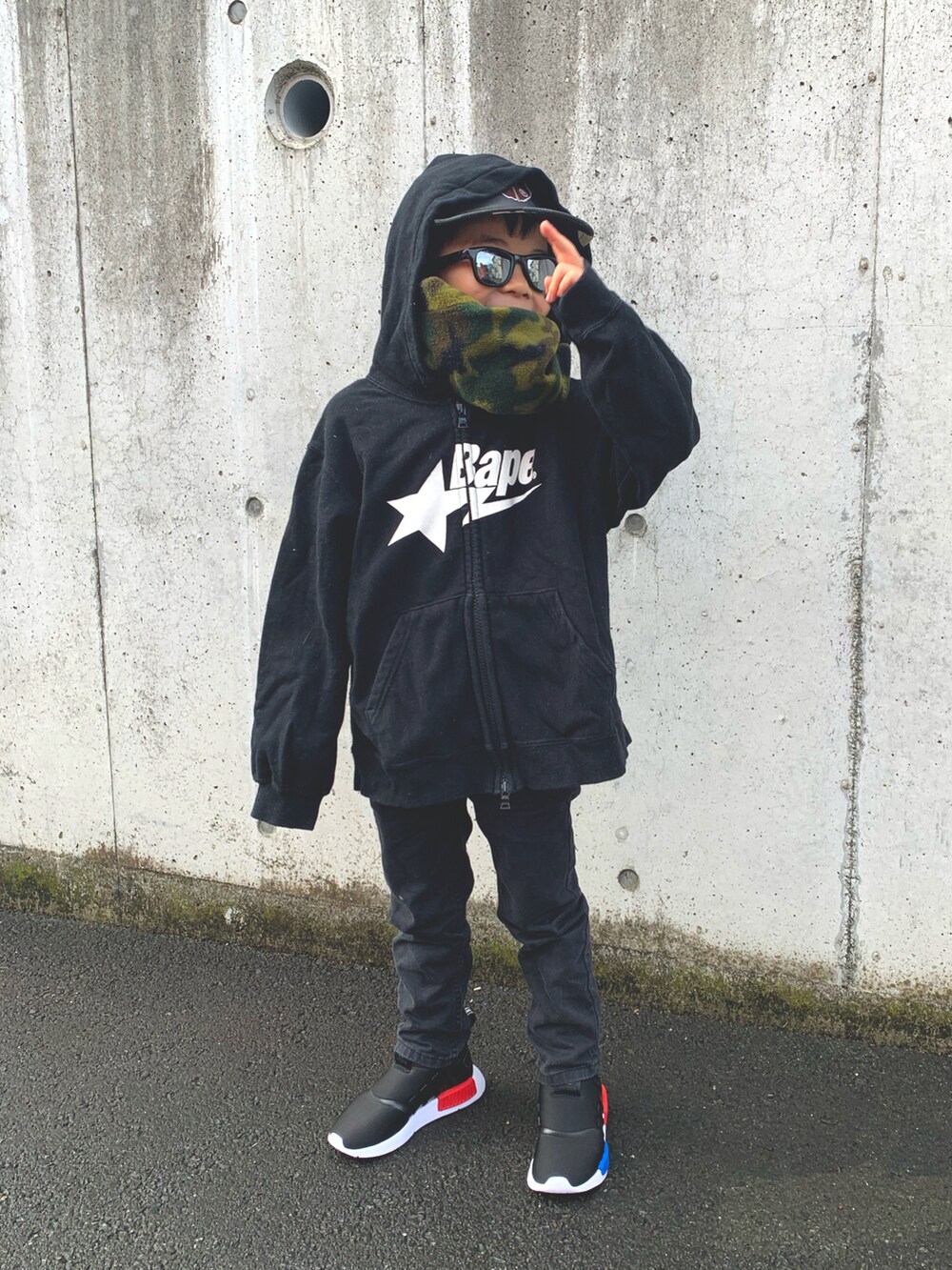 ブラック系のパーカー、ブラック系のデニムパンツ、ブラック系のスニーカーを着用したキッズの冬コーディネートの3枚目の写真