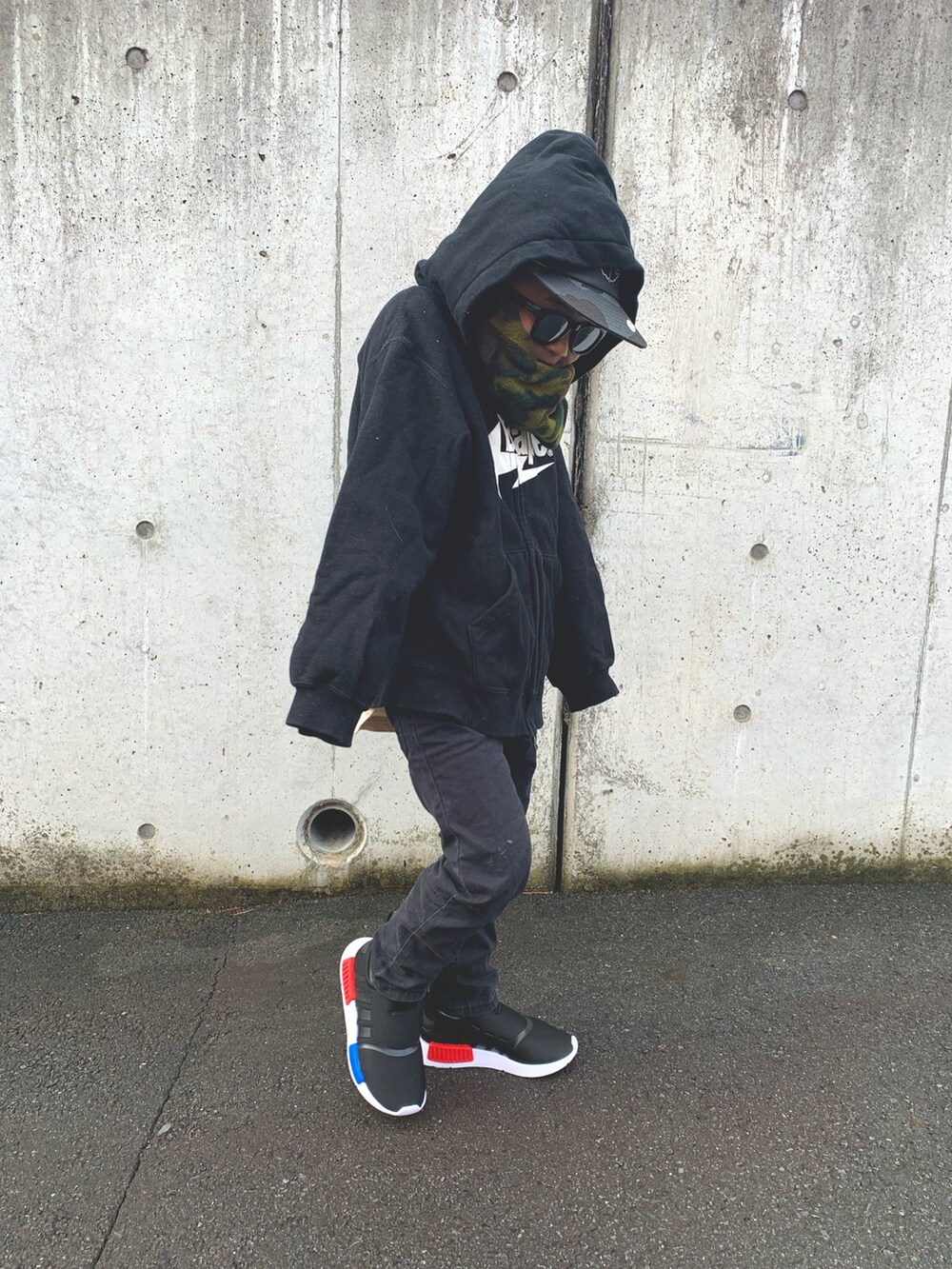 ブラック系のパーカー、ブラック系のデニムパンツ、ブラック系のスニーカーを着用したキッズの冬コーディネートの2枚目の写真