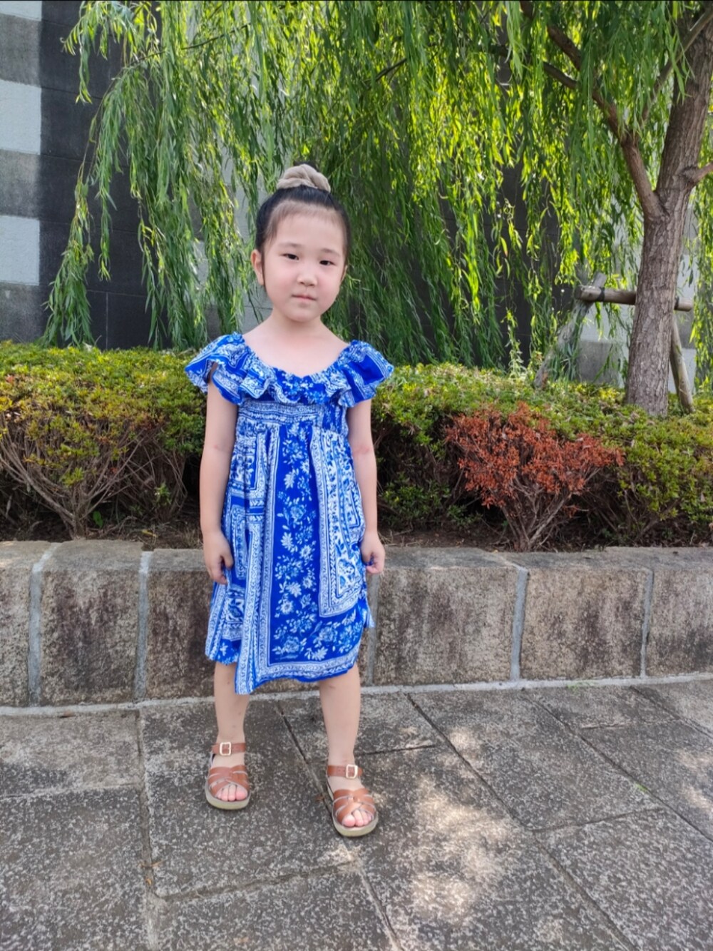 ブルー系のワンピース、ブラウン系のサンダルを着用したキッズの夏コーディネートの2枚目の写真