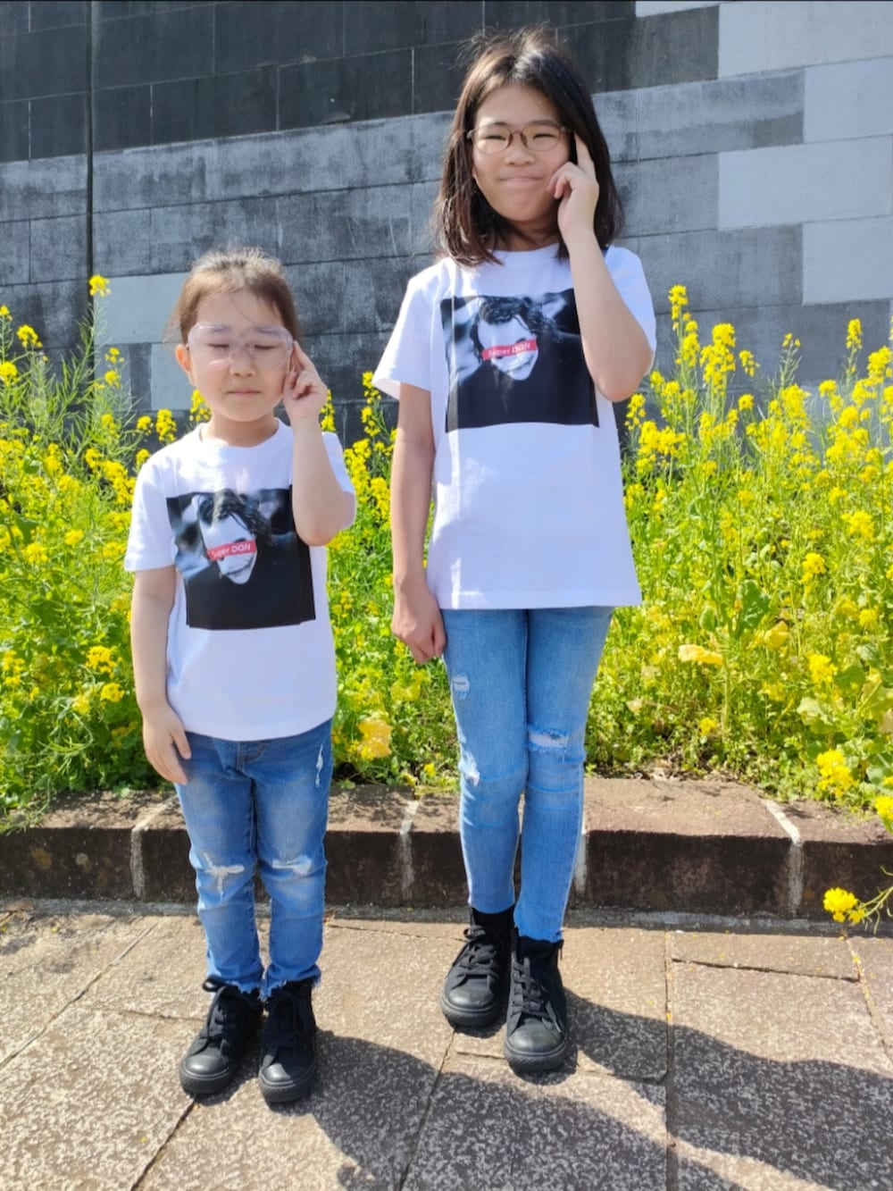 ブラック系のスニーカーを着用したキッズの春コーディネートの2枚目の写真