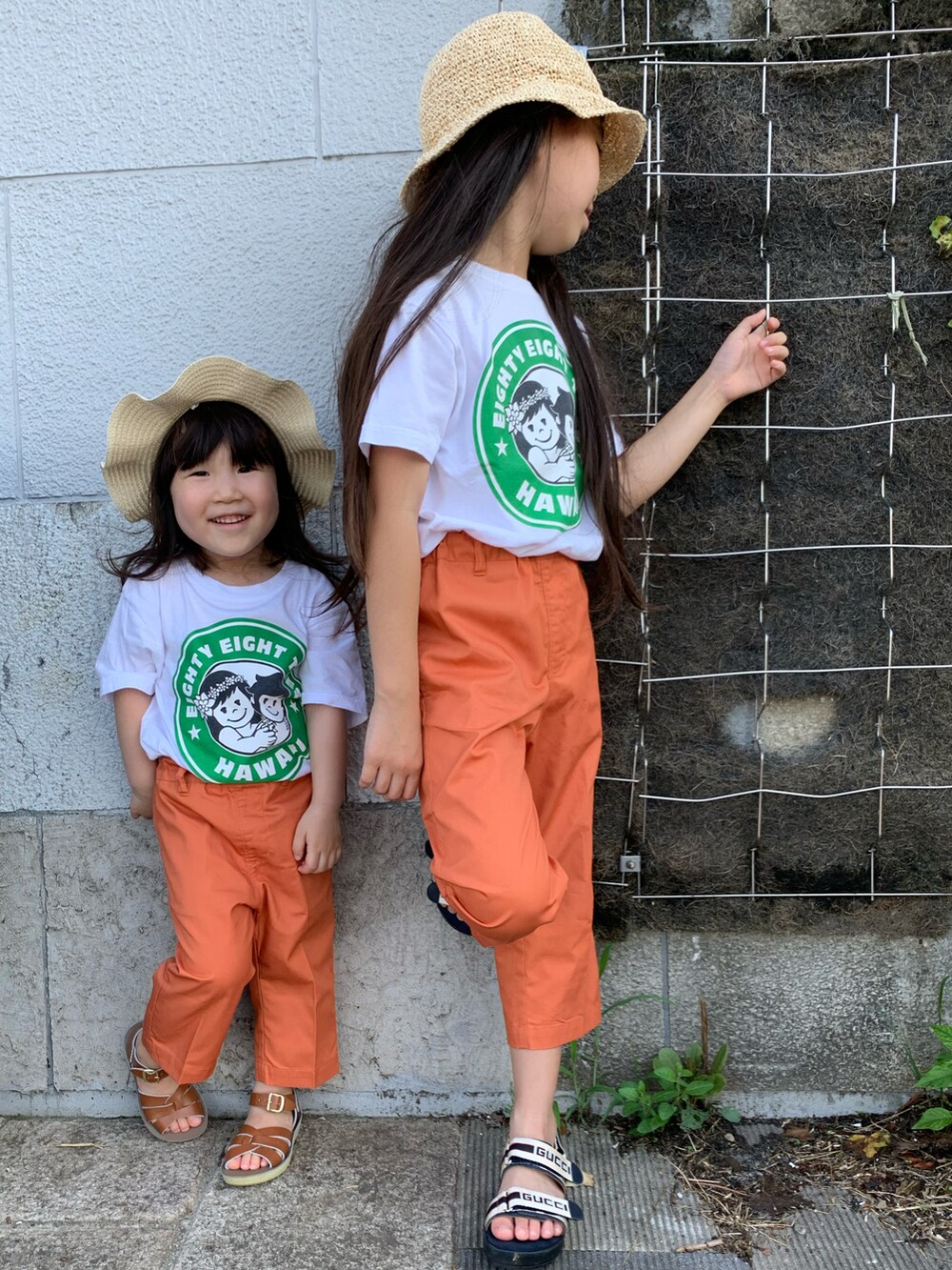 ホワイト系のTシャツ/カットソー、オレンジ系のその他パンツ、ブラウン系のサンダルを着用したキッズの夏コーディネートの3枚目の写真