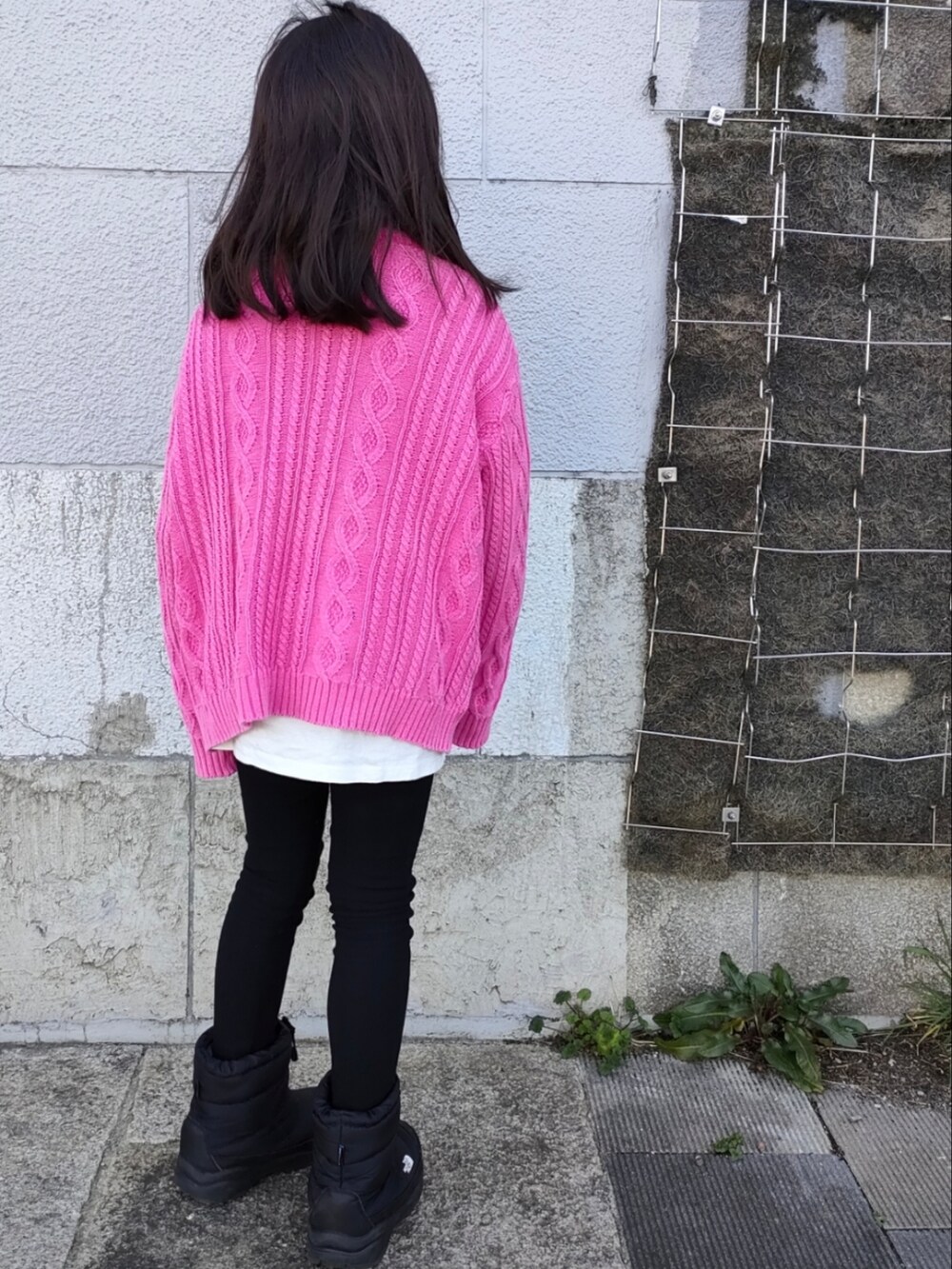 イエロー系のニット/セーター、ブラック系のその他パンツ、ブラック系のブーツを着用したキッズの春コーディネートの2枚目の写真