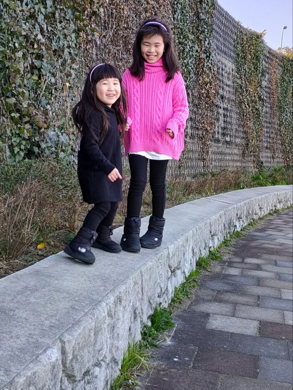 イエロー系のニット/セーター、ブラック系のその他パンツ、ブラック系のブーツを着用したキッズの春コーディネートの4枚目の写真