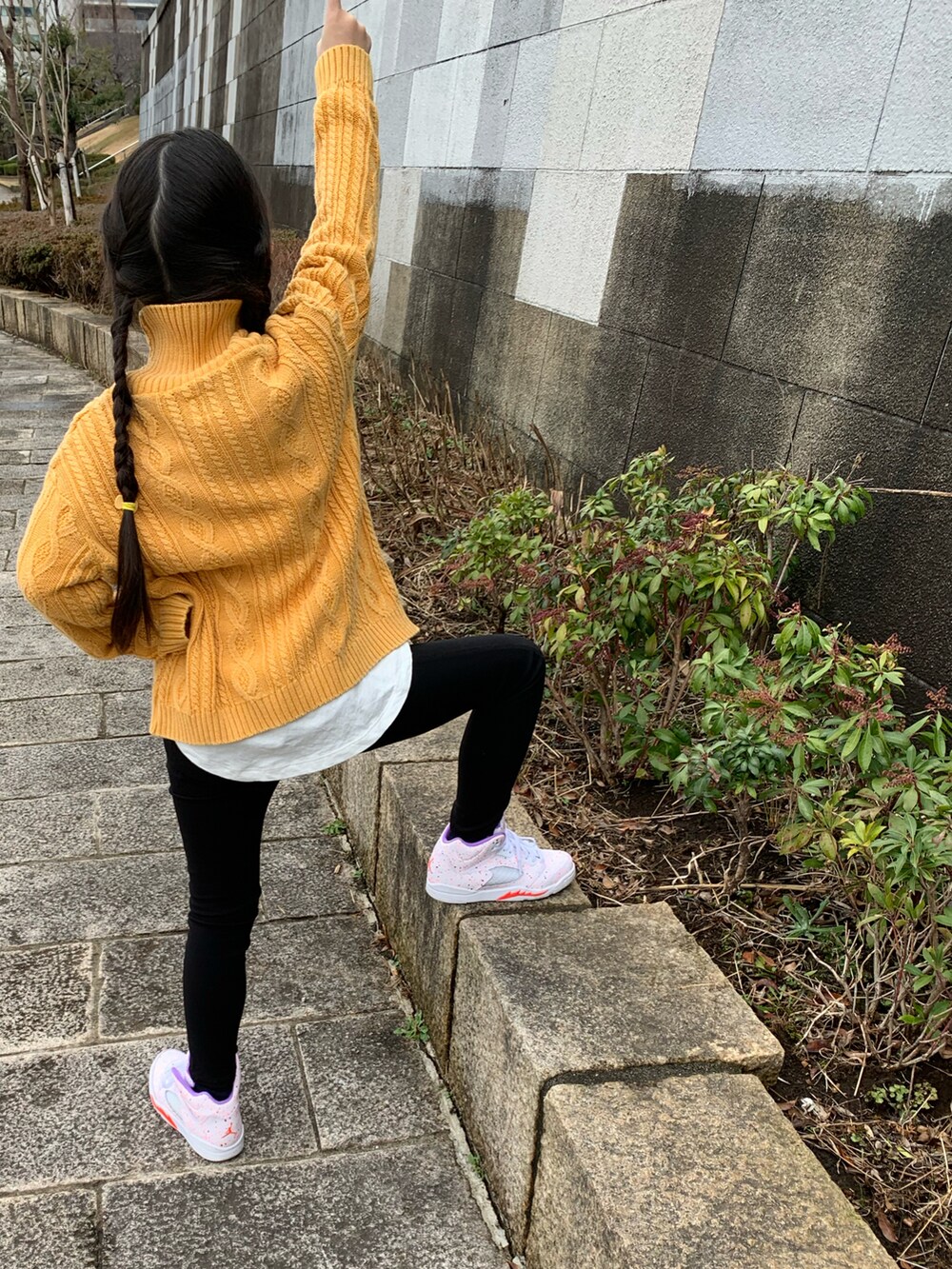 イエロー系のニット/セーター、ブラック系のその他パンツ、ホワイト系のスニーカーを着用したキッズの冬コーディネートの2枚目の写真