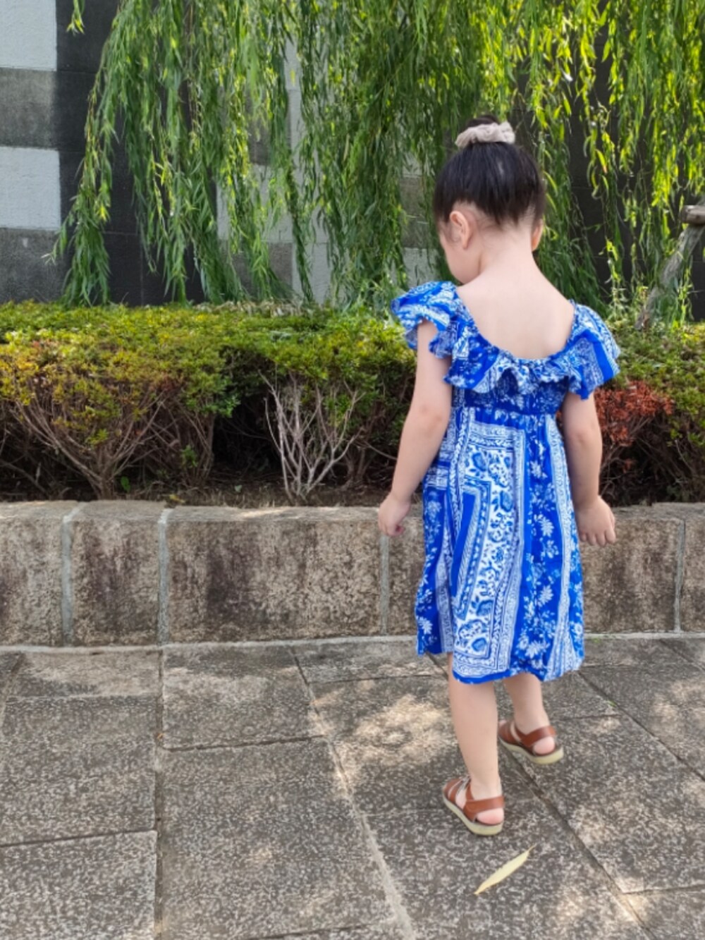 ブルー系のワンピース、ブラウン系のサンダルを着用したキッズの夏コーディネートの3枚目の写真