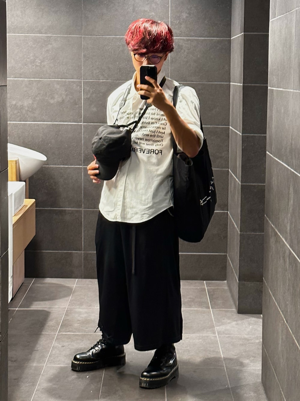 ブラック系のトートバッグ、ホワイト系のシャツ/ブラウス、ブラック系のパンツを着用したメンズの秋コーディネートの2枚目の写真