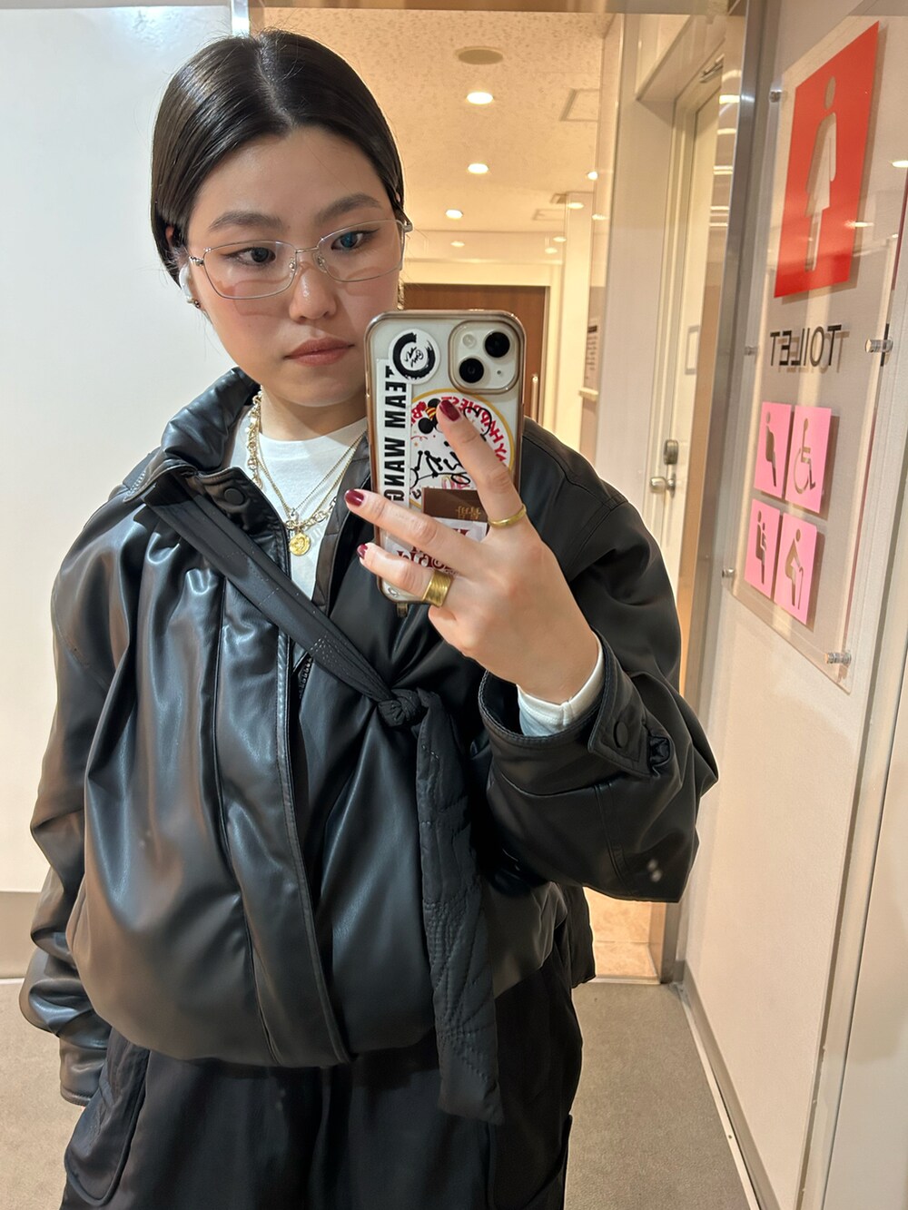 ブラック系のブルゾン、ブラック系のパンツ、グレー系のスニーカーを着用したレディースの冬コーディネートの2枚目の写真