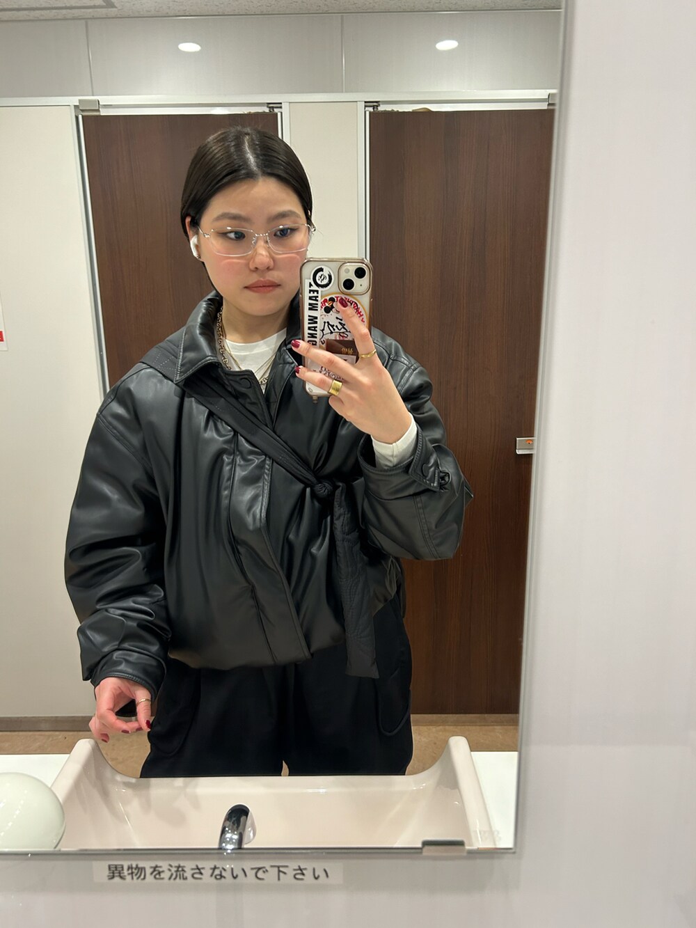ブラック系のブルゾン、ブラック系のパンツ、グレー系のスニーカーを着用したレディースの冬コーディネートの3枚目の写真