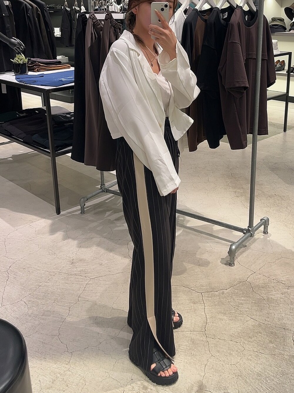 ブラック系のスラックスを着用したレディースの夏コーディネートの2枚目の写真