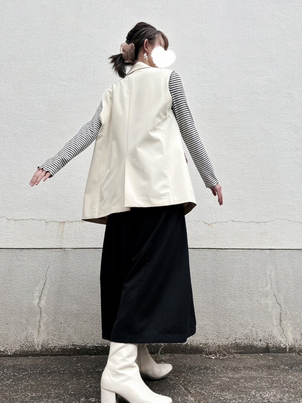 ベージュ系のその他アウター、ブラック系のジャンパースカート、ホワイト系のTシャツ/カットソーを着用したレディースの春コーディネートの2枚目の写真