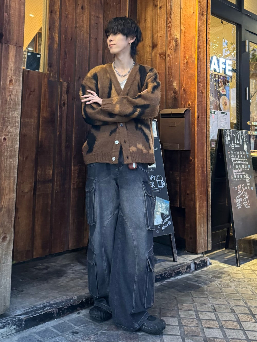 ブラウン系のカーディガン/ボレロ、ブラック系のカーゴパンツ、ブラック系のスニーカーを着用したメンズの冬コーディネートの2枚目の写真