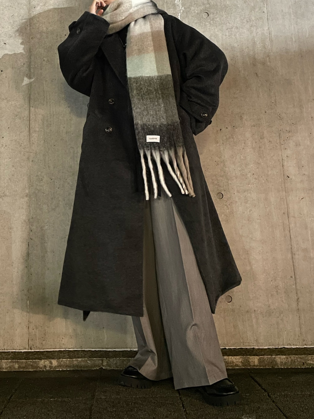 グレー系のスラックス、ブラック系のローファー、グレー系のニット/セーターを着用したメンズの冬コーディネートの2枚目の写真