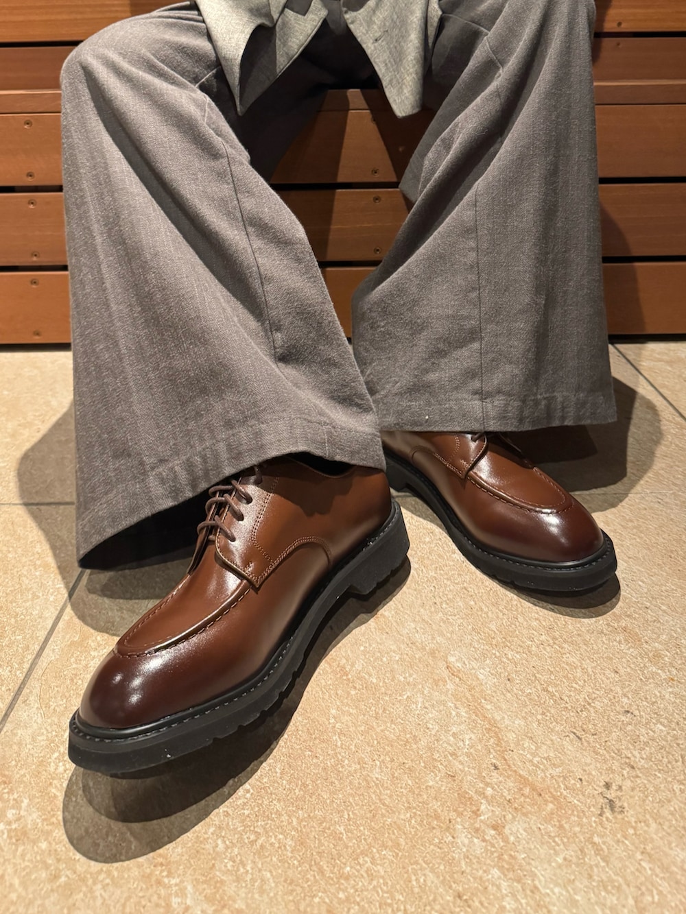 ベージュ系のテーラードジャケット、レッド系のカーディガン/ボレロ、グリーン系のスラックスを着用したメンズの秋コーディネートの3枚目の写真