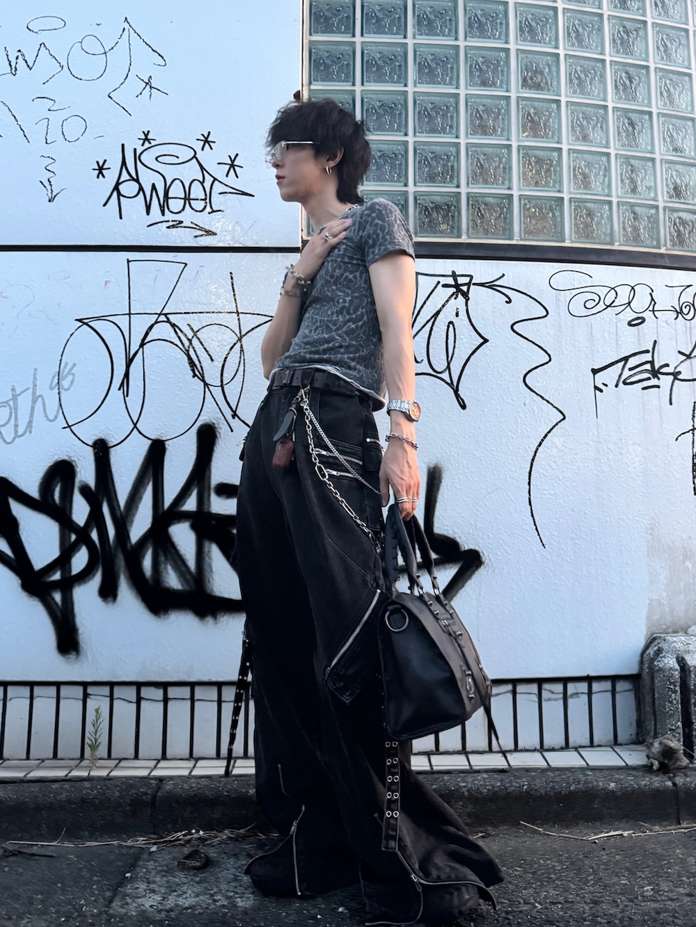 グレー系のTシャツ/カットソー、ブラック系のデニムパンツ、ブラック系のボストンバッグを着用したメンズの夏コーディネートの2枚目の写真